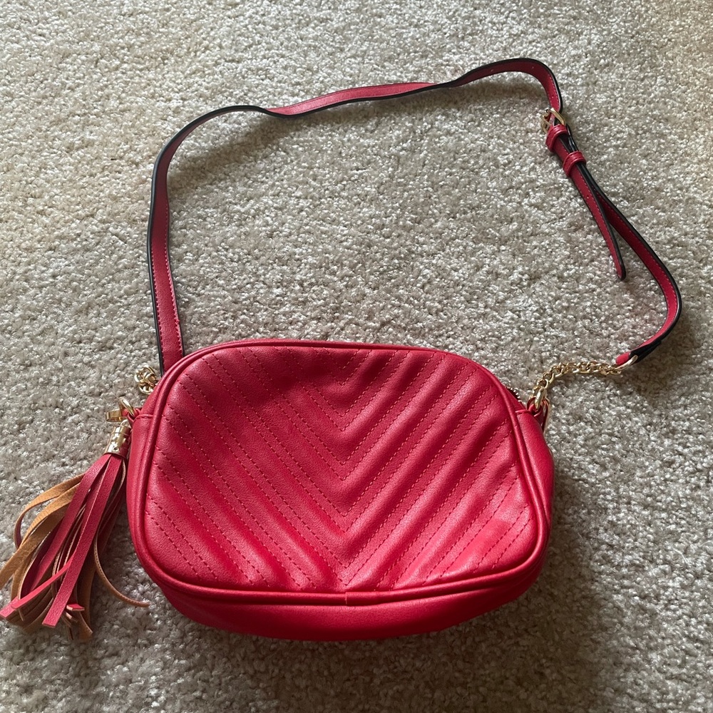 Red leather cross body bag with gold zipper and chain